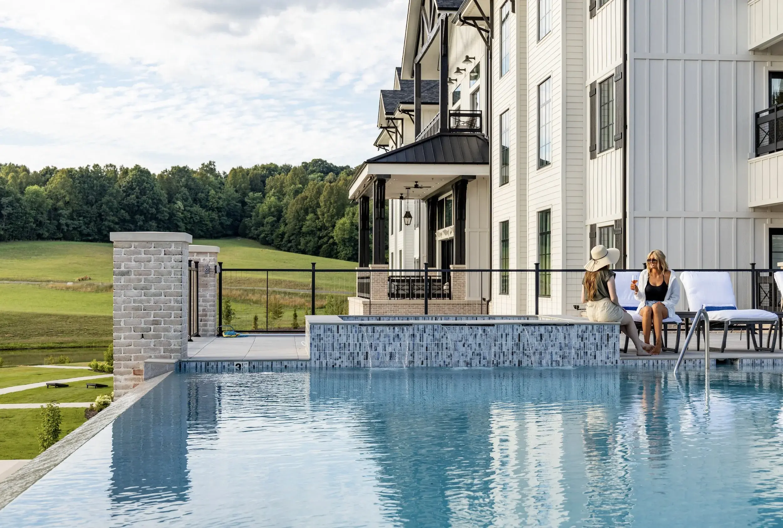 women lounging beside pool